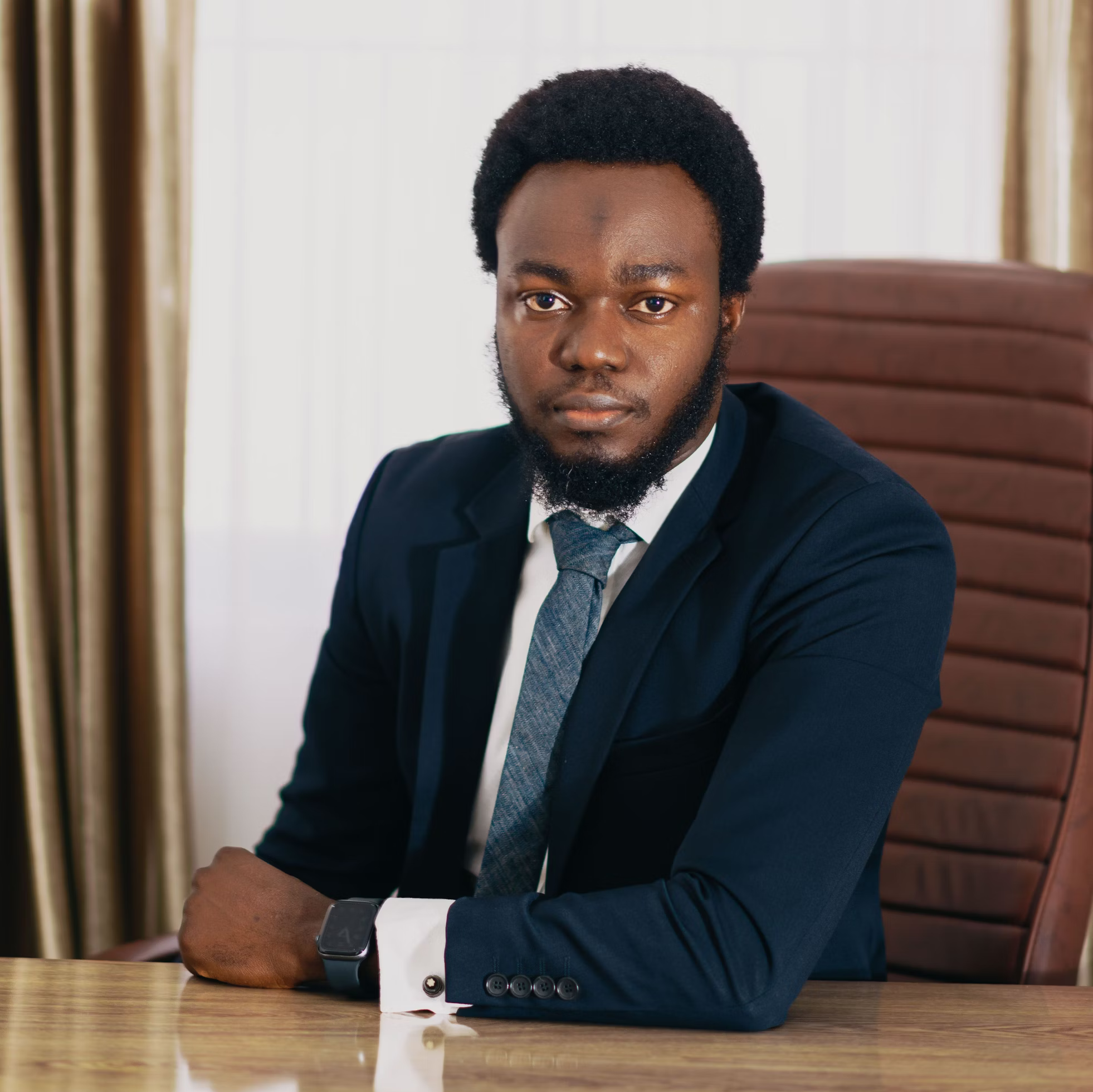 A man in a suit sitting at a table as a representation of a CEO.