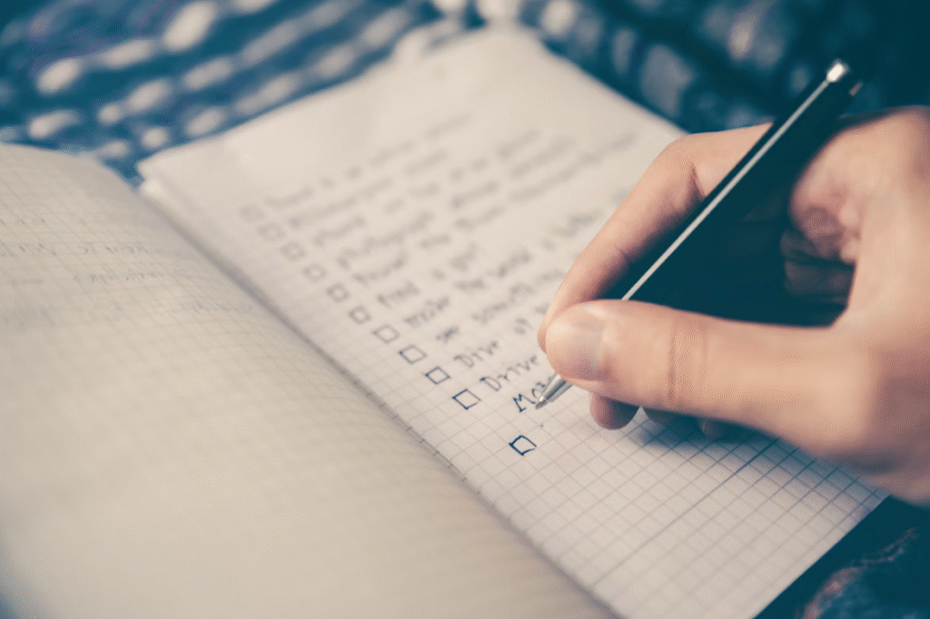 A person writes down a checklist to help manage their executive dysfunction.
