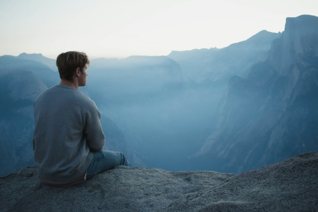 A person looking into the distance, taking a moment to breathe and consider thoughts and feelings that may contribute to cognitive overhead.