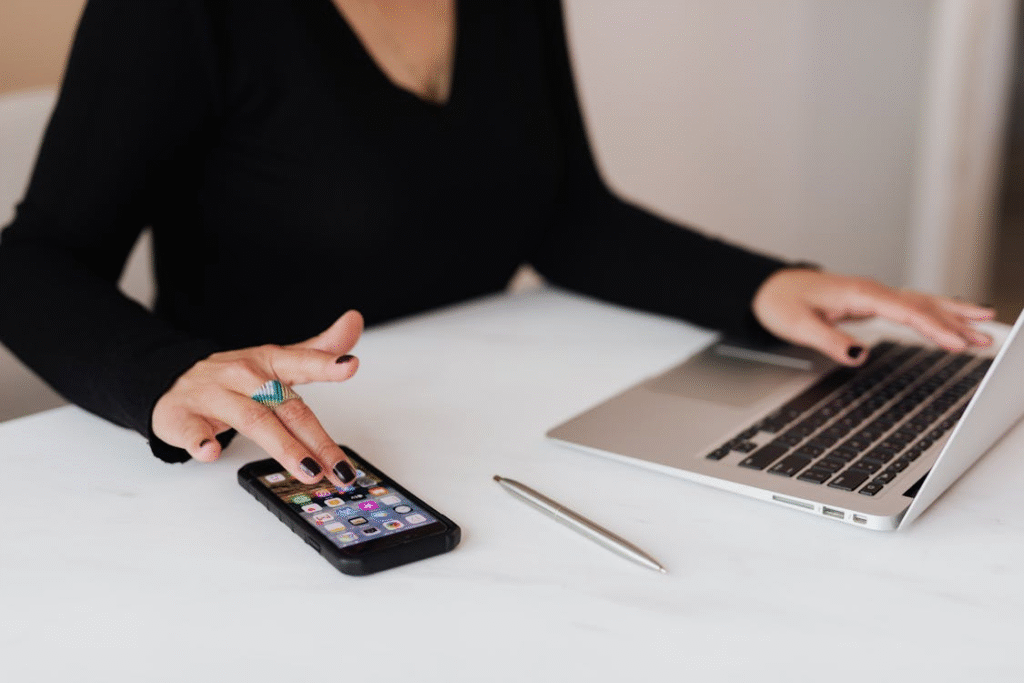 A woman multitasking on her smartphone and laptop instead of switching between each task.